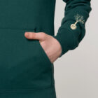Sweat pour homme et femme en coton biologique de couleur vert sapin avec un dessin dans le dos représentant les cinq éléments de sérigraphie beige. Logo de la marque sérigraphié sur la manche.