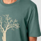 Tshirt homme manche courte couleur vert jade avec le dessin d'un arbre sur une planète et sérigraphie de couleur beige.
