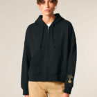 Veste sweat femme en coton biologique de couleur noir avec le dessin d'une montagne et inscription silence dans le dos en sérigraphie doré. Logo de la marque sur la manche.