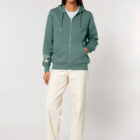 Veste sweat pour homme et femme en coton biologique de couleur vert jade avec un dessin de montagne dans le dos et une inscription noté silence de sérigraphie beige.